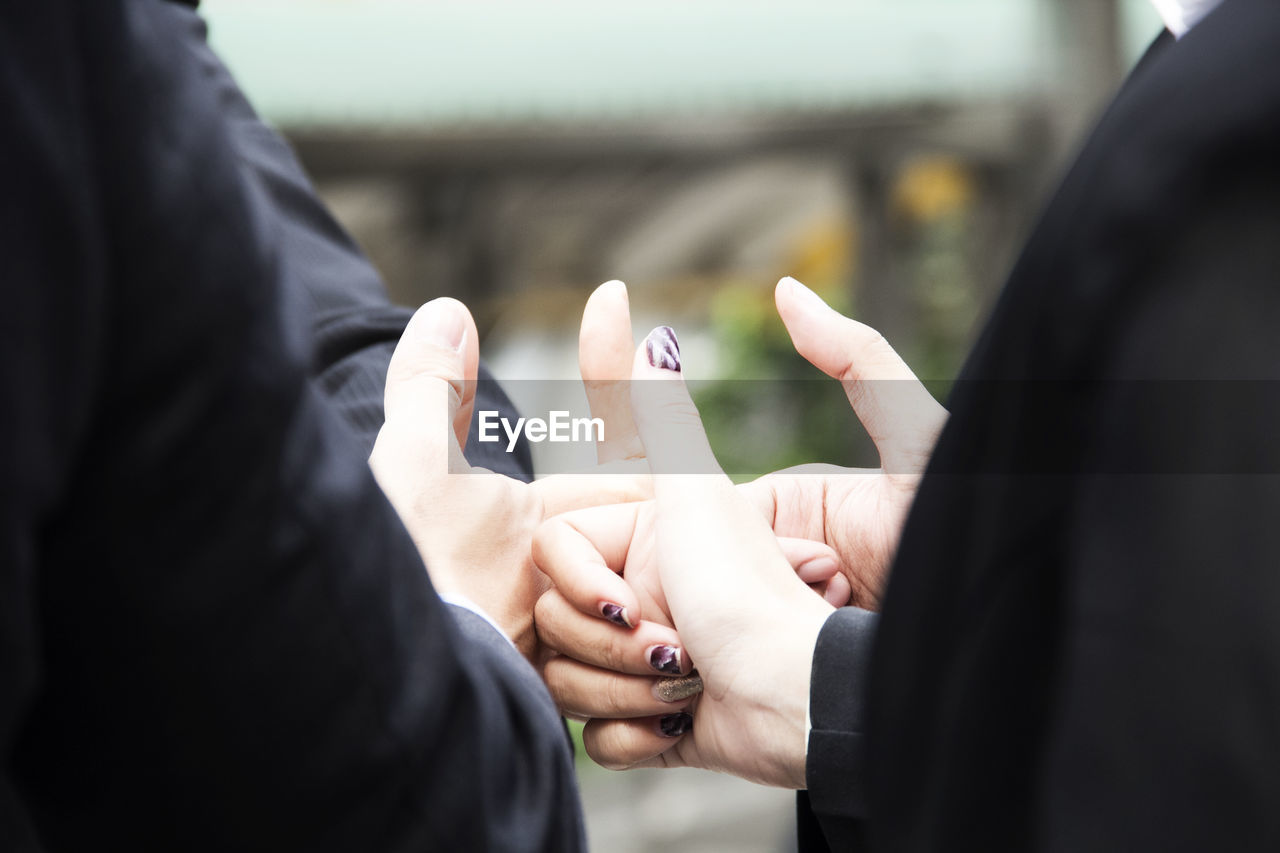 Cropped image of friends gesturing thumbs up