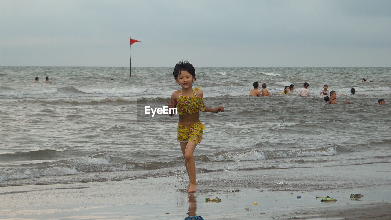 WOMAN STANDING ON BEACH