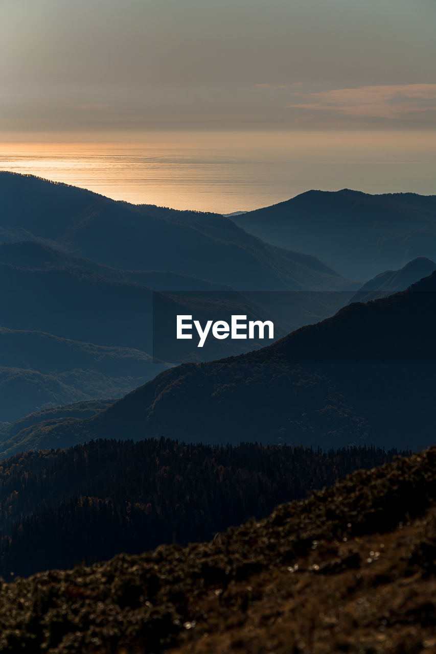 SCENIC VIEW OF MOUNTAINS AGAINST SKY AT SUNSET