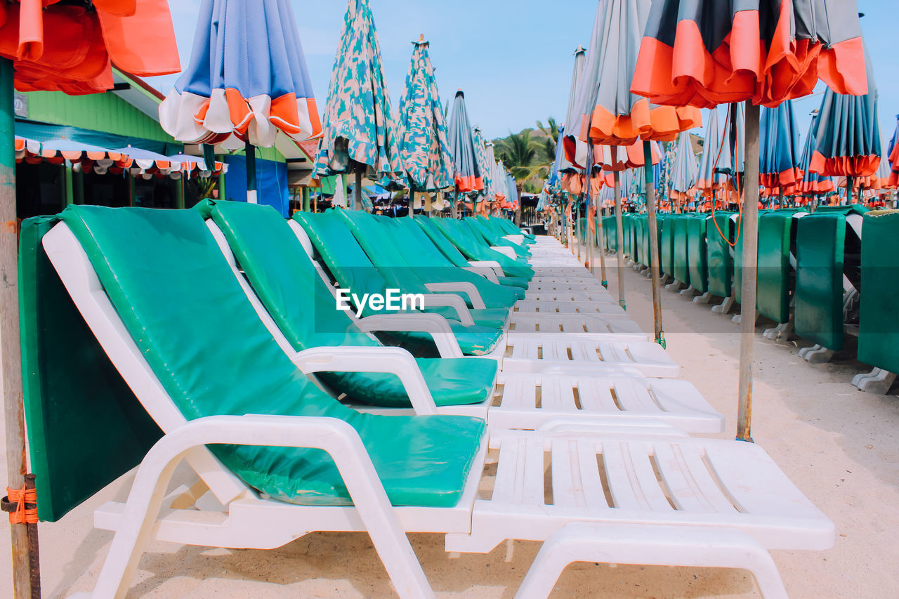 Chairs at beach against sky