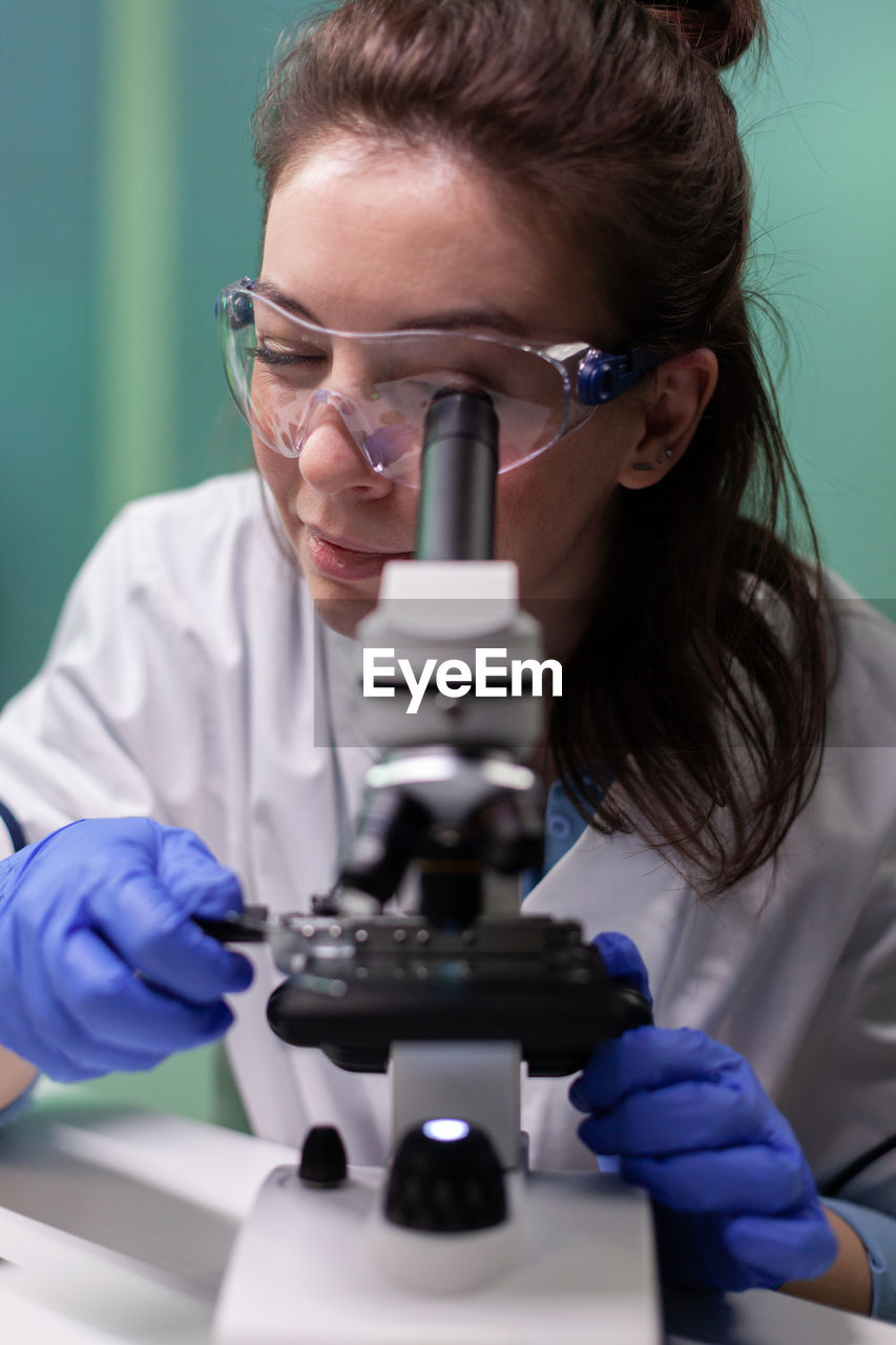 Scientist using microscope at lab