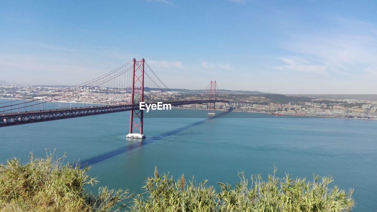 Scenic view of 25 de abril bridge over tagus river against sky