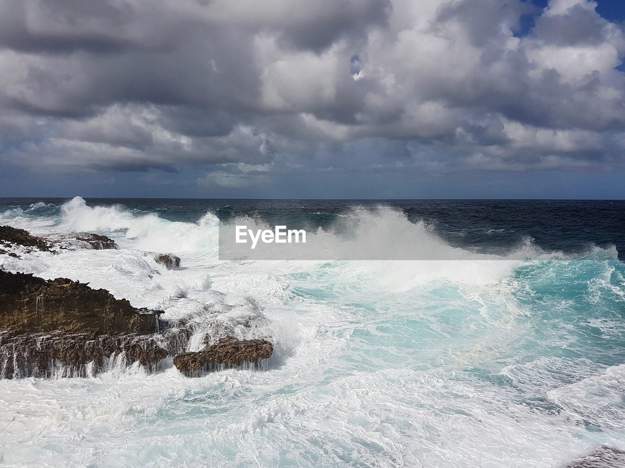 Scenic view of sea against storm clouds