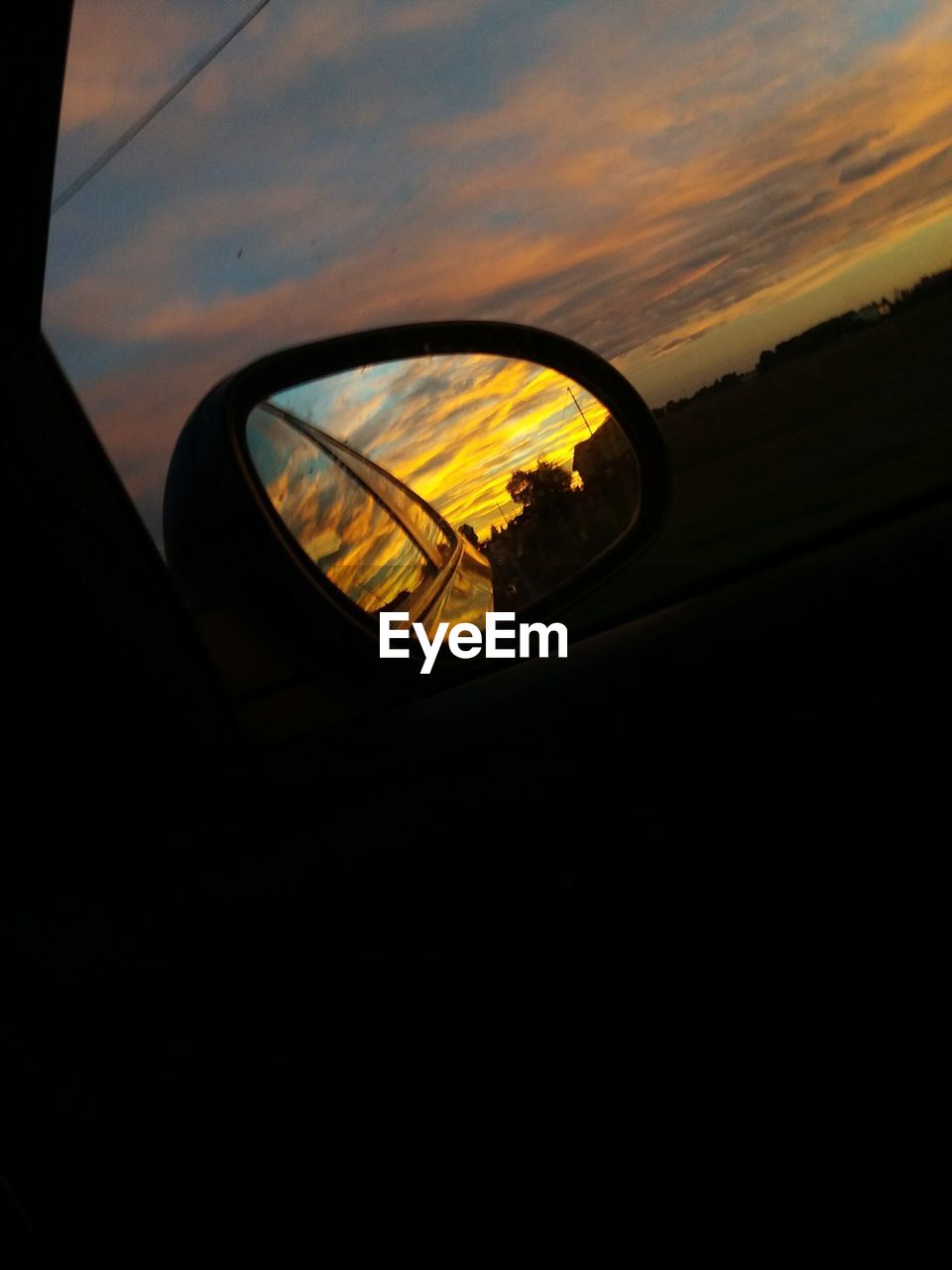 REFLECTION OF CAR ON SIDE-VIEW MIRROR AGAINST SKY