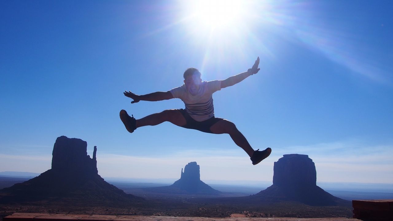 MAN JUMPING AGAINST CLEAR SKY