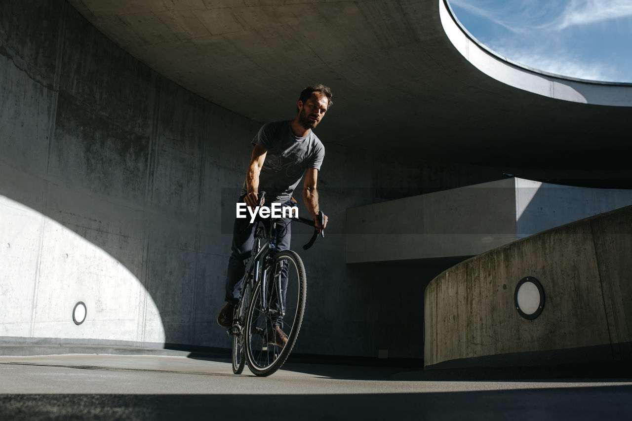 YOUNG MAN RIDING BICYCLE ON WALL