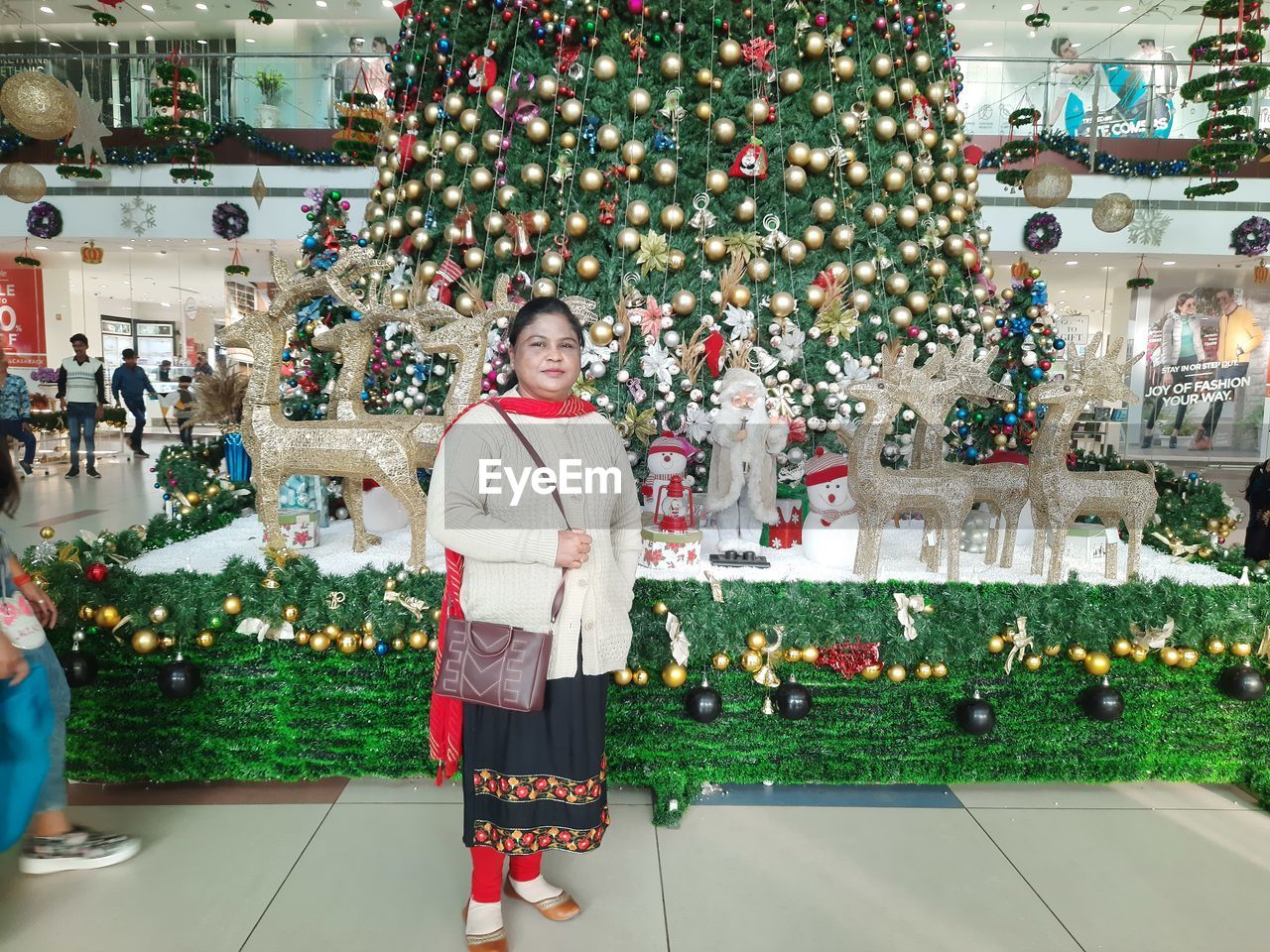 Portrait of woman standing against christmas tree