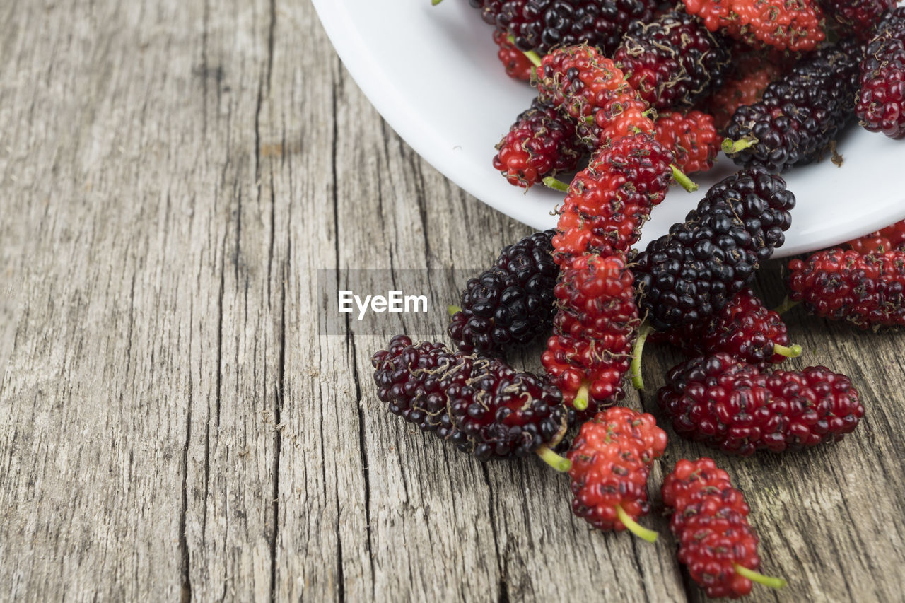 HIGH ANGLE VIEW OF STRAWBERRIES IN CONTAINER ON TABLE