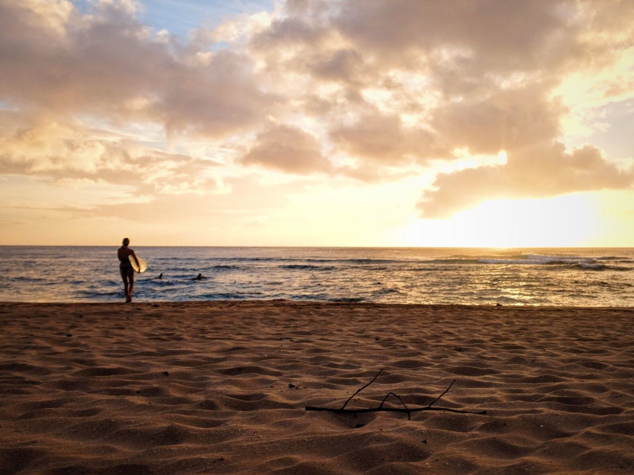 Person on shore at beach during sunset