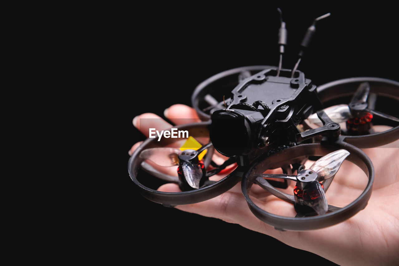 Hands holding a racing drone with a camera. woman holding a radio-controlled mini quadcopter