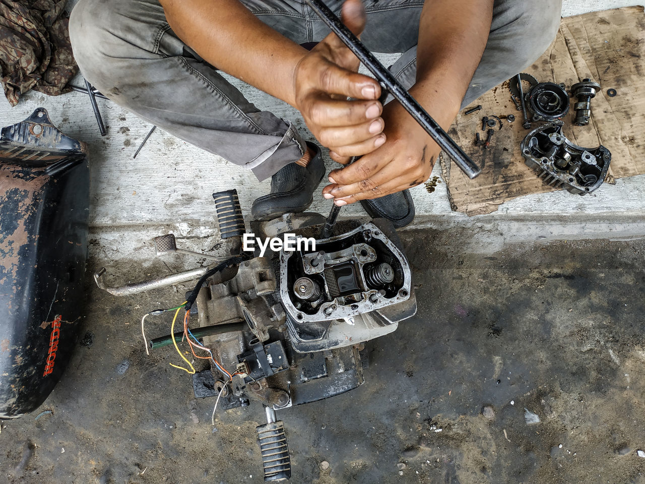 Low section of man repairing equipment