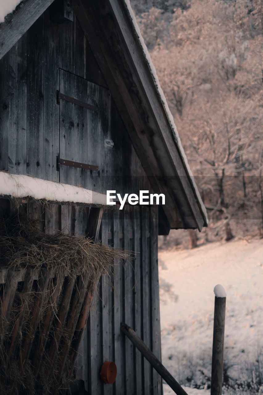 Close-up of old wooden building, barn, cabin with hay in winter