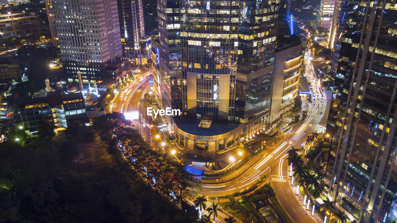 High angle view of illuminated street amidst buildings at night