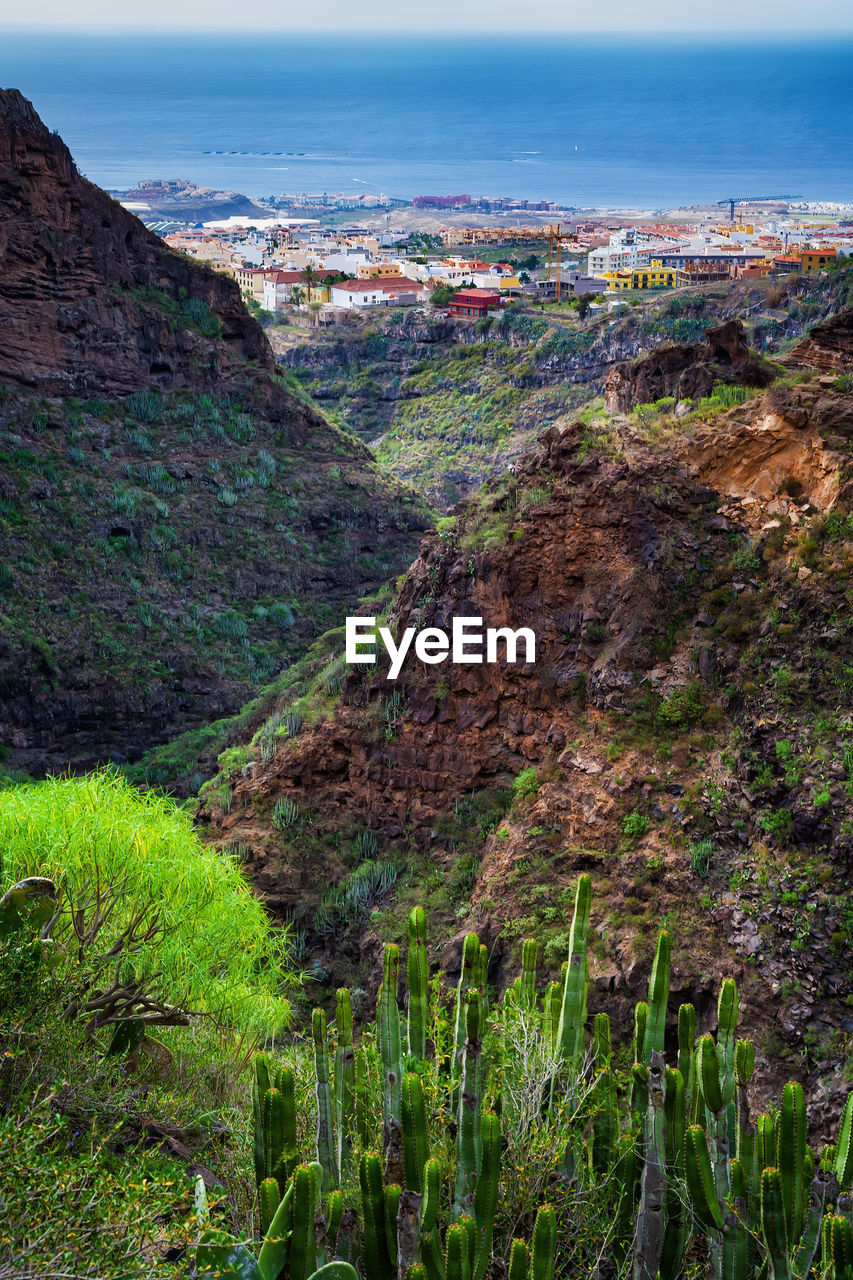 HIGH ANGLE VIEW OF BUILDINGS AND MOUNTAINS