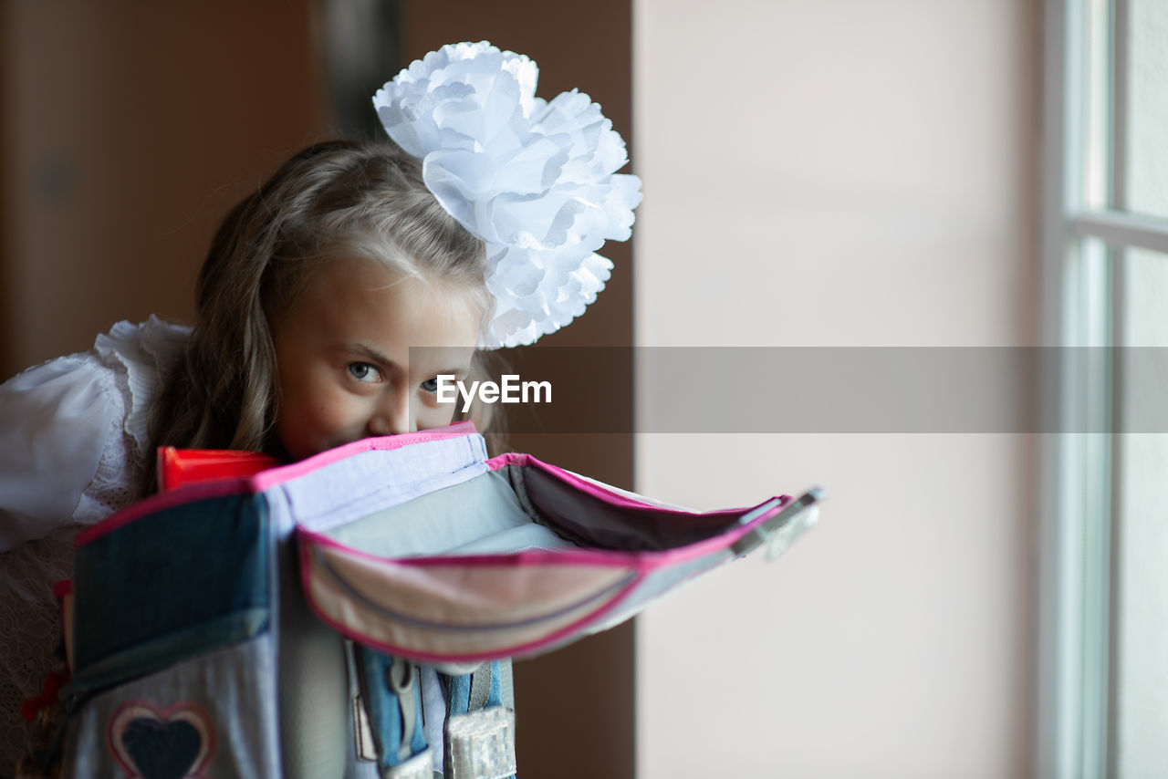 Portrait of cute girl packing bag at home