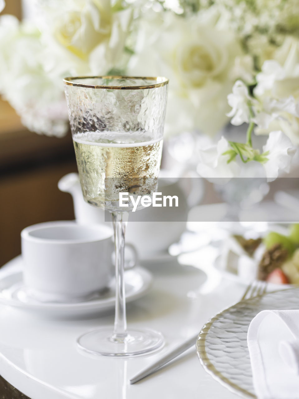 Table serves for banquet. champagne in modern stylish wine glass, plates with napkins and cutlery