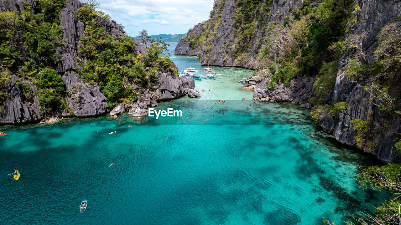 water, land, sea, scenics - nature, beauty in nature, turquoise colored, nature, beach, travel destinations, rock, travel, environment, body of water, tranquility, coastline, tree, sky, landscape, tranquil scene, idyllic, vacation, tourism, trip, mountain, holiday, coast, island, tropical climate, lagoon, plant, cliff, bay, blue, bay of water, no people, non-urban scene, rock formation, outdoors, cloud, day, terrain, nautical vessel, summer, forest, seascape, relaxation, cove, high angle view, panoramic, aerial view, pinaceae