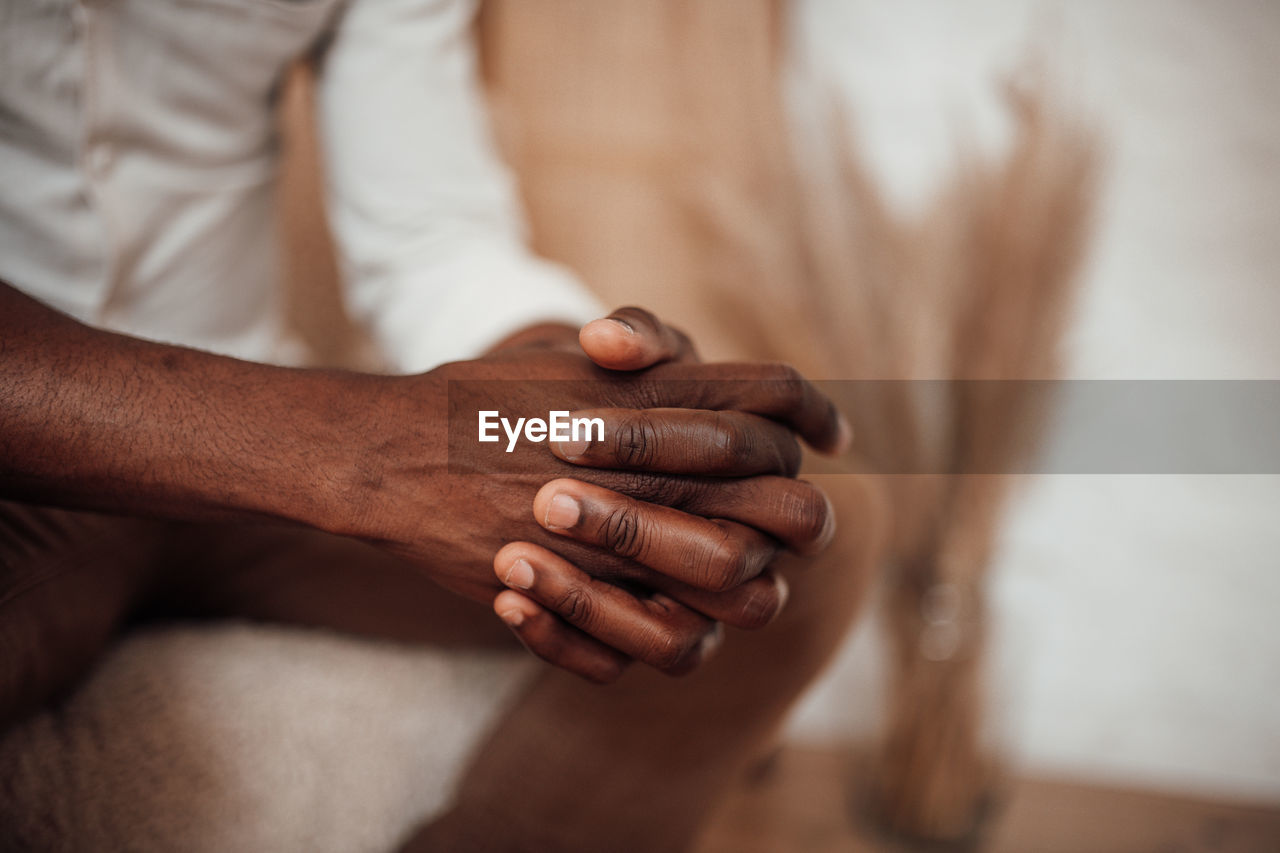 Close-up of man holding hands over blurred background