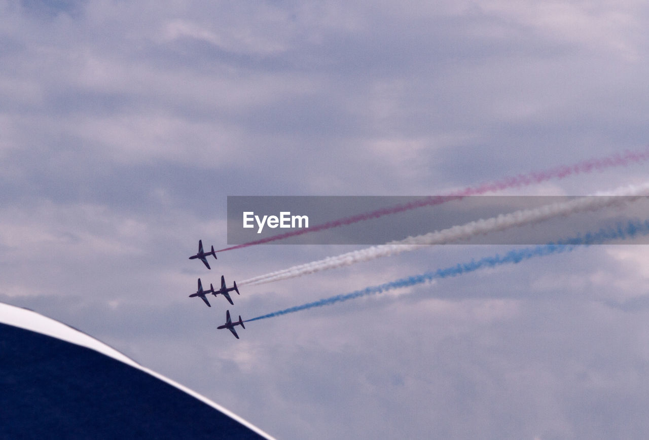 Low angle view of airplanes flying against sky