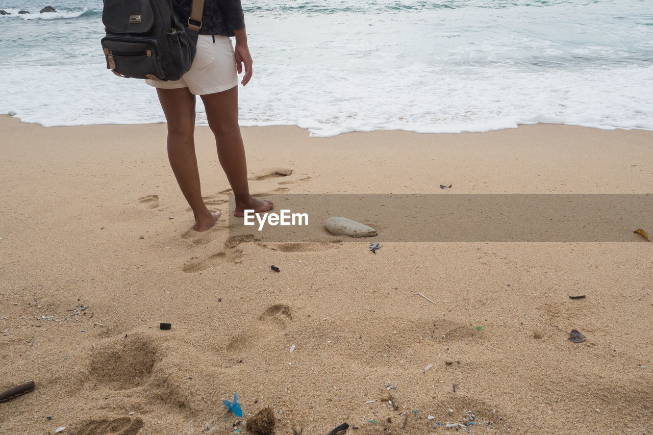 Low section of woman standing on beach