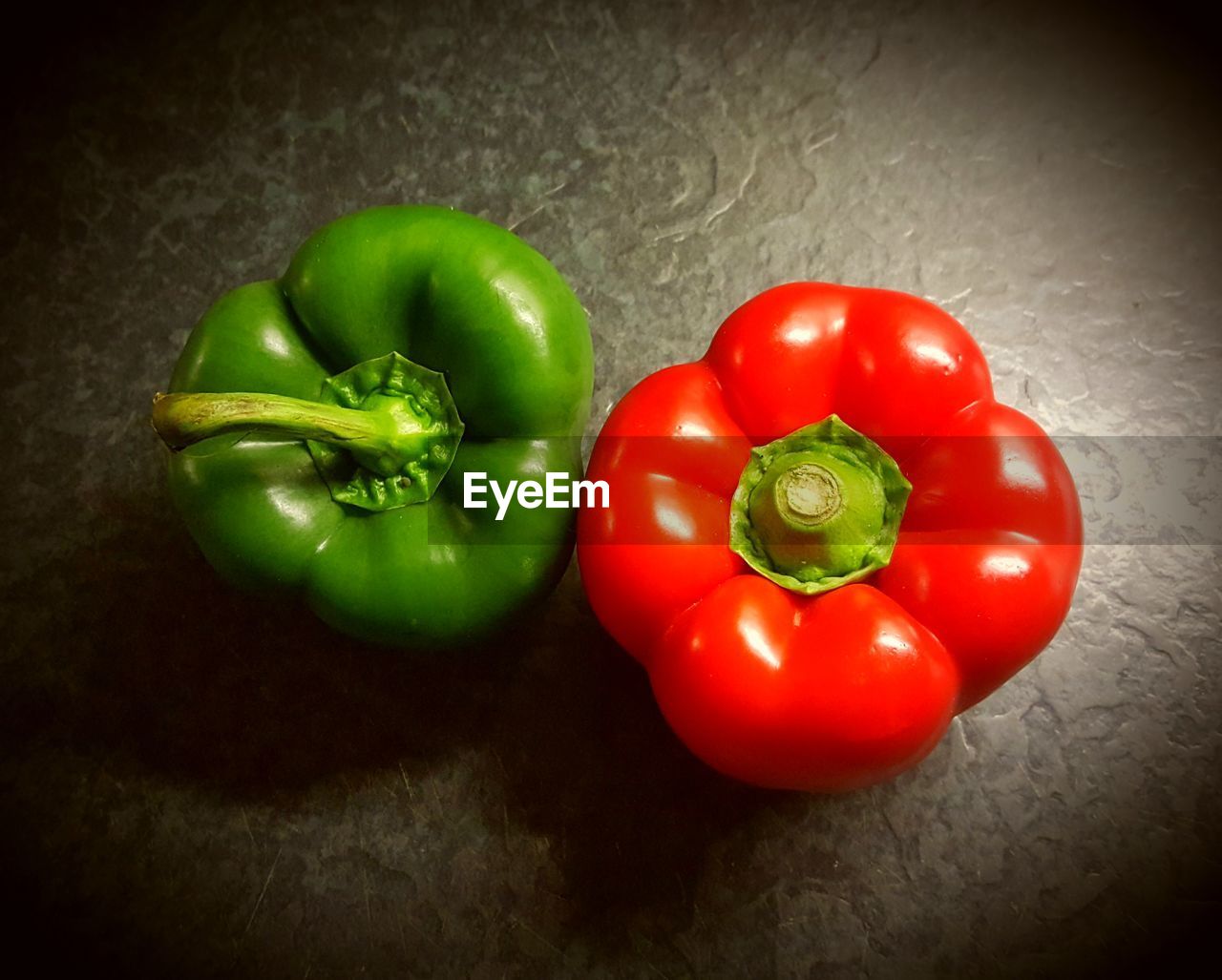 HIGH ANGLE VIEW OF TOMATOES AND BELL PEPPERS ON GREEN BACKGROUND