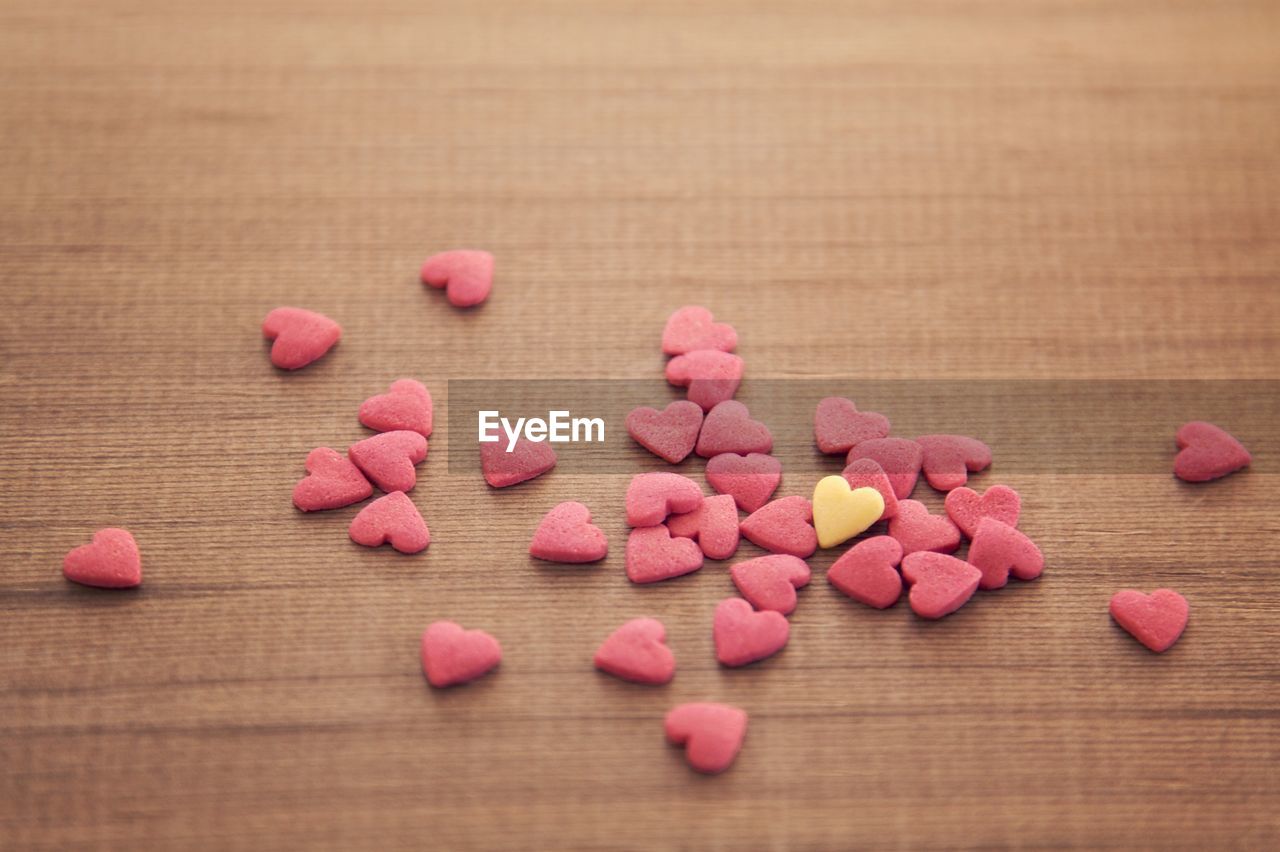 High angle view of heart shape candies on wooden table