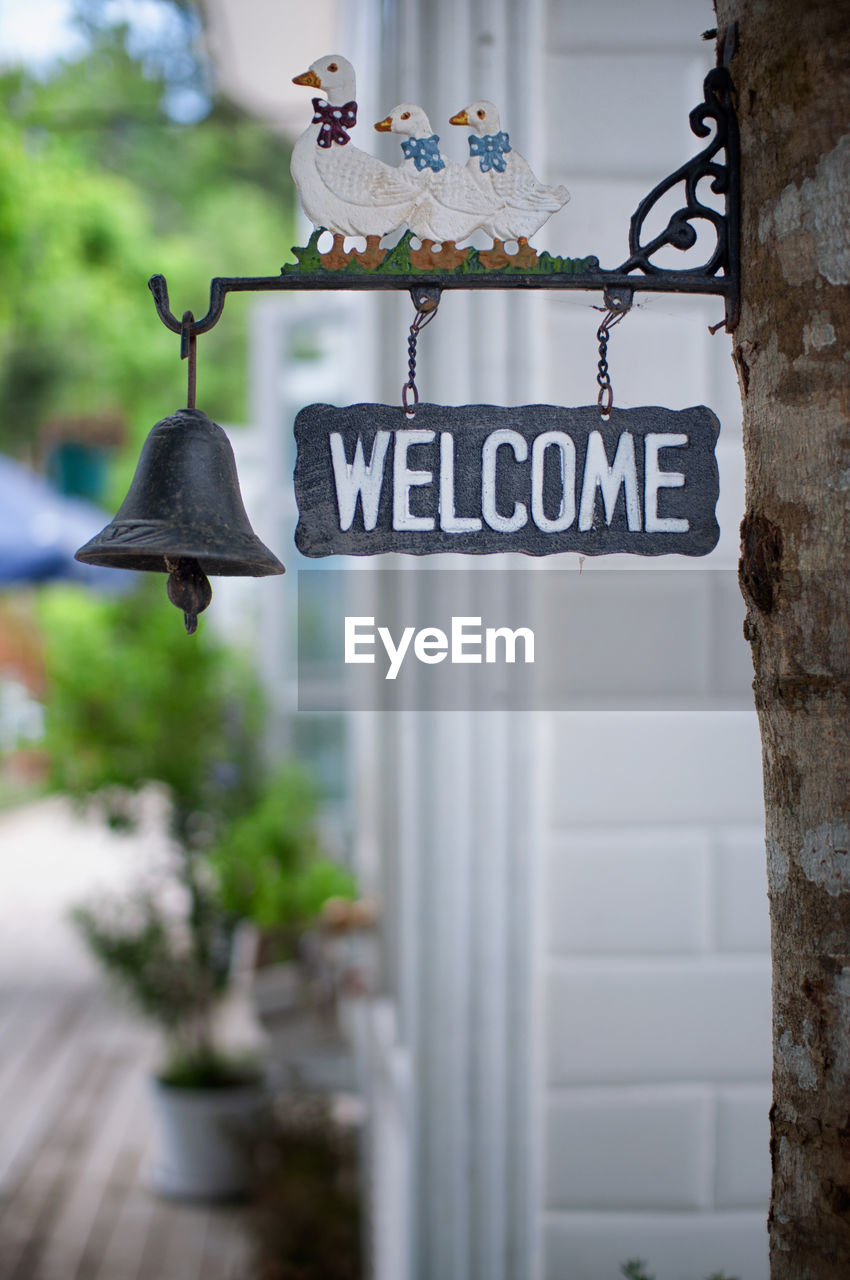 Welcome sign with bell hanging on tree