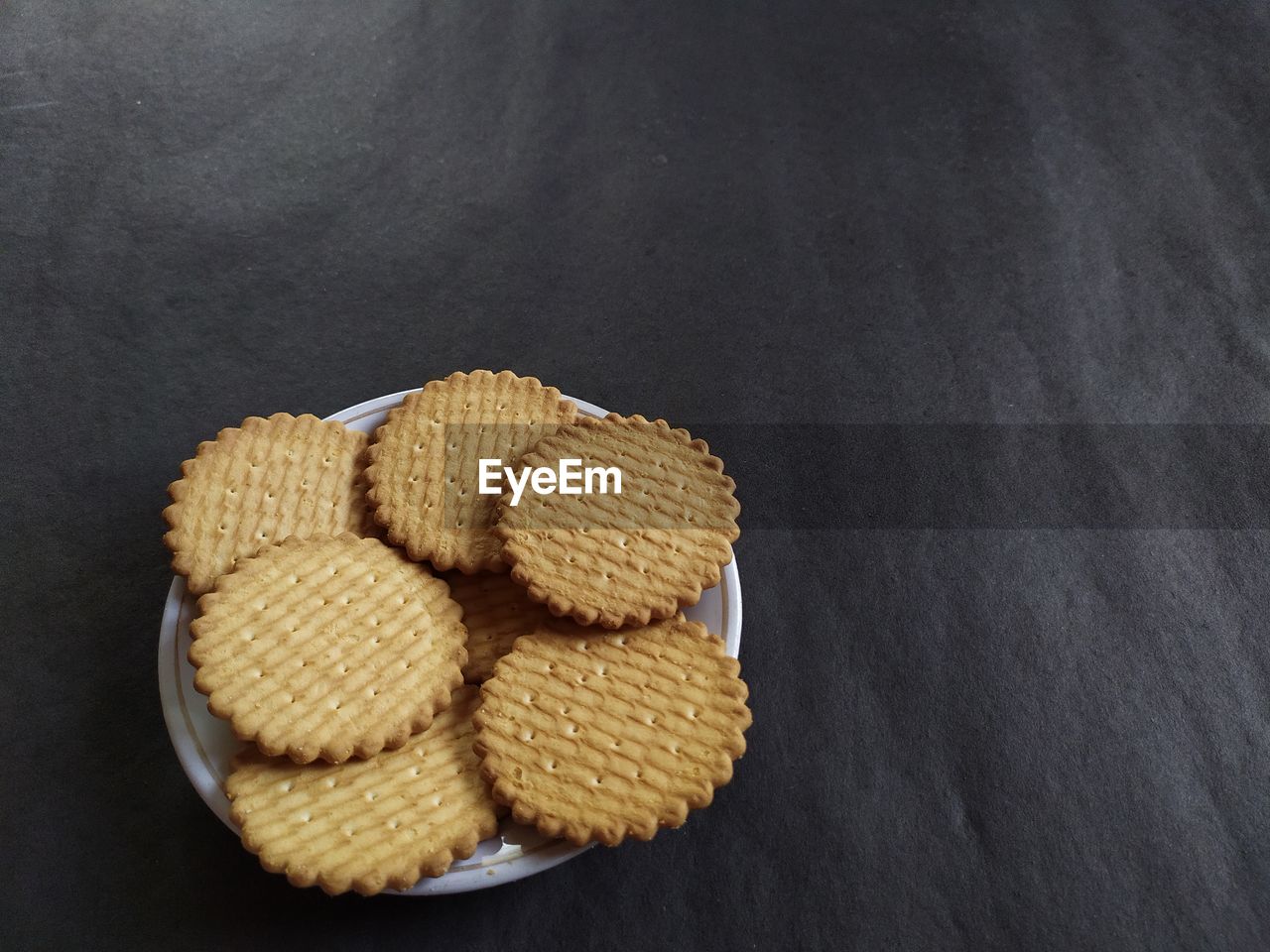 Biscuits on a plate, black background.