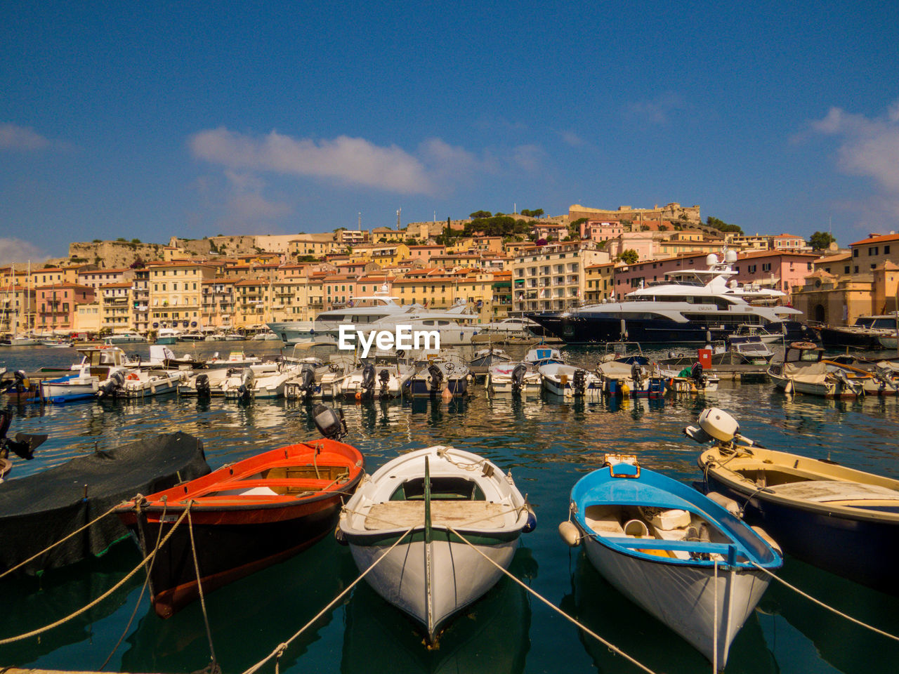 HIGH ANGLE VIEW OF BOATS MOORED AT HARBOR IN CITY