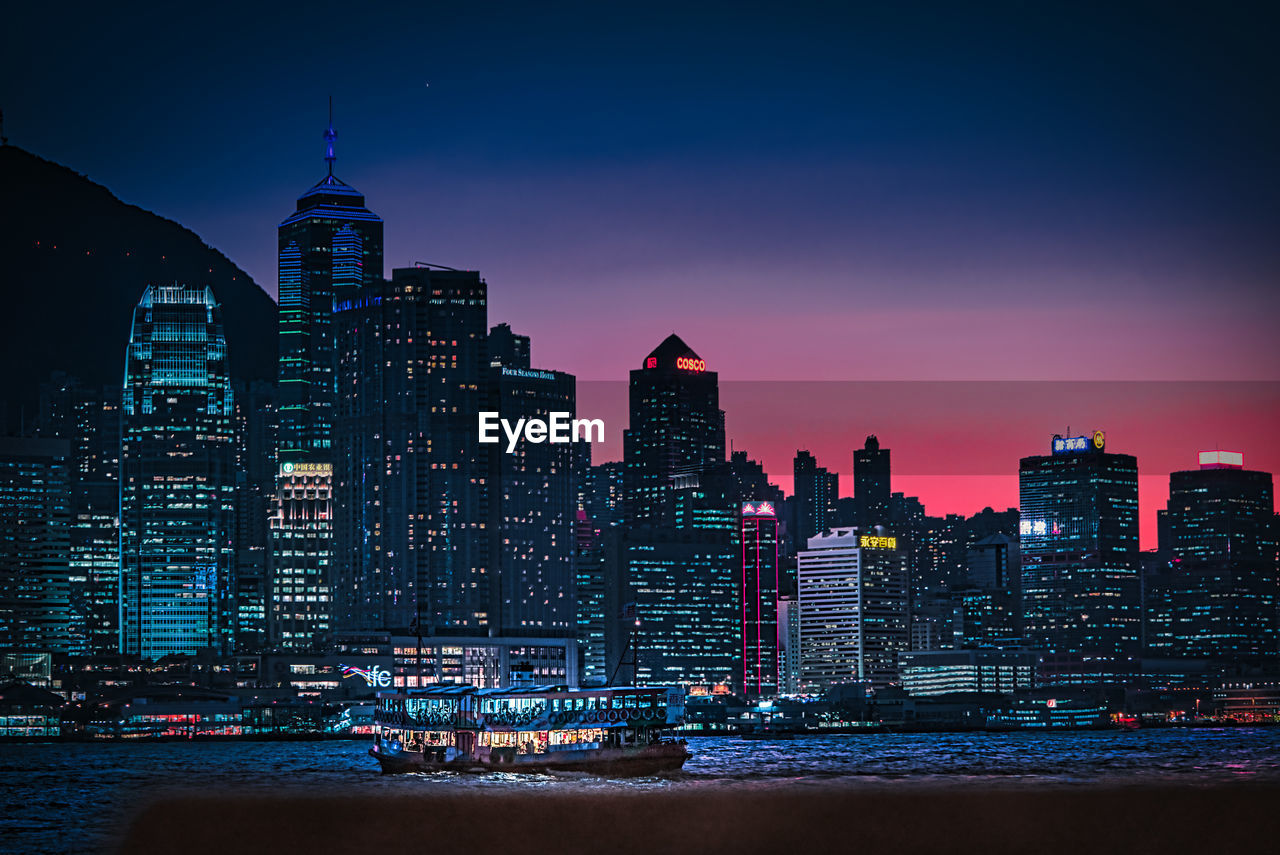 ILLUMINATED CITY BUILDINGS AGAINST SKY