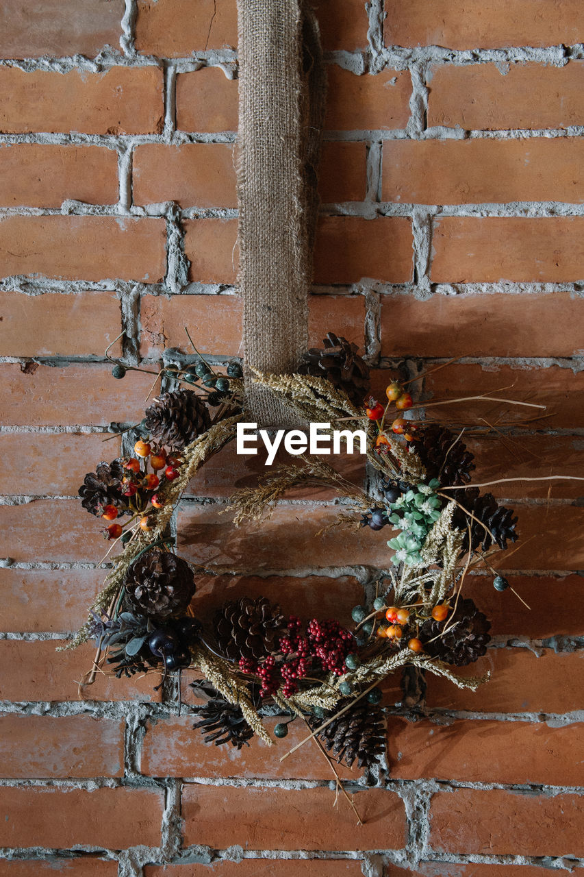 Close-up of wreath hanging on brick wall