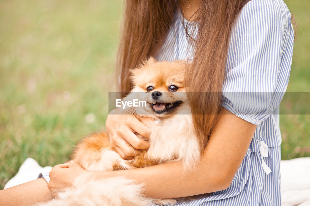 Portrait of woman with dog on grass