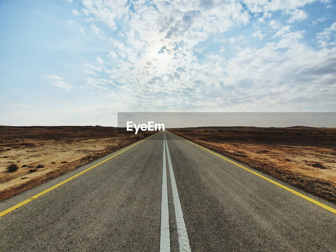Road passing through landscape against sky