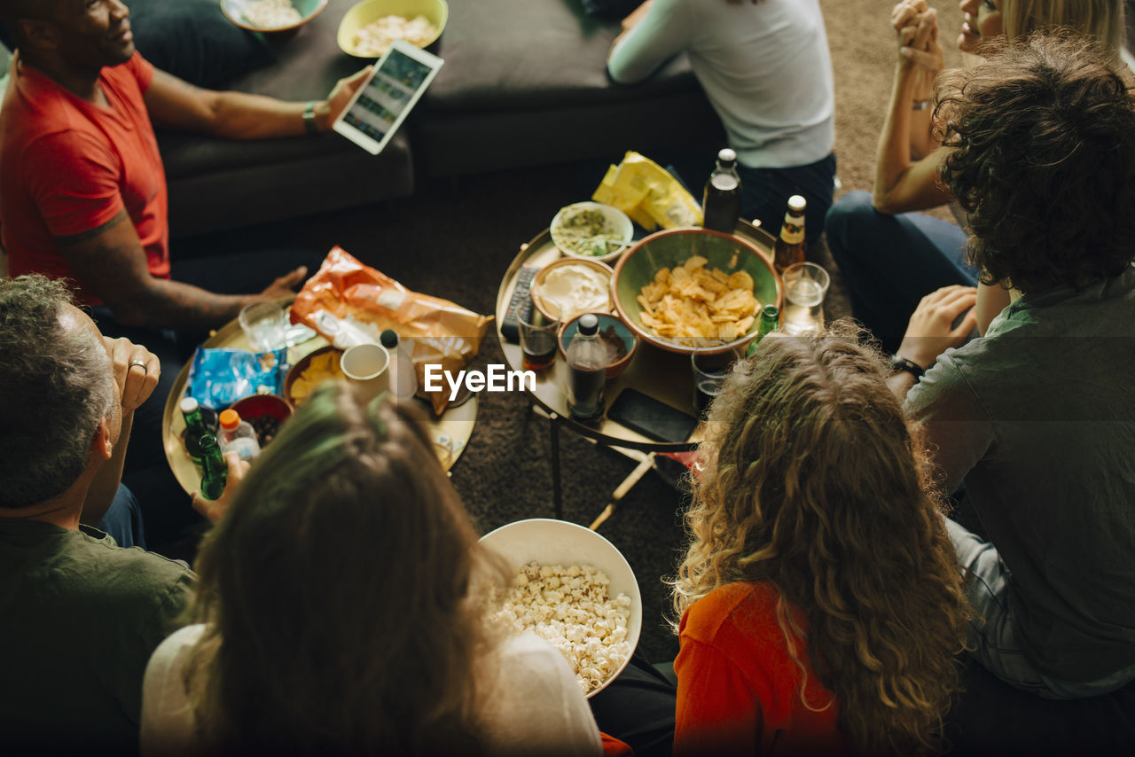 High angle view of sports fans watching tv together at night