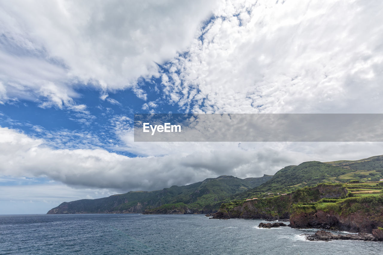 Scenic view of sea and mountains against sky