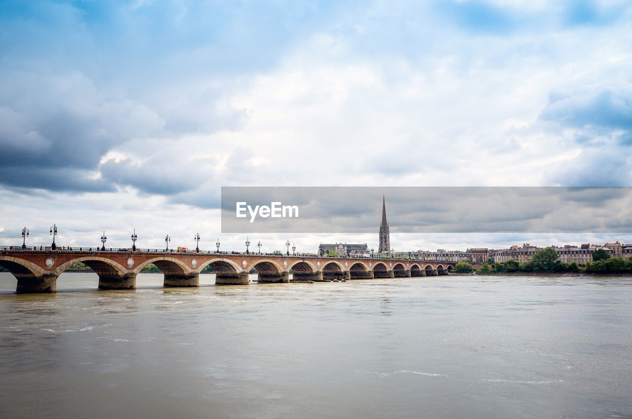 View of arch bridge over river against sky