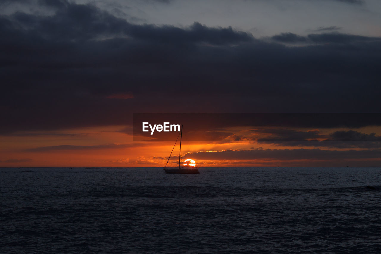 Scenic view of a boat in the sea against sky during sunset