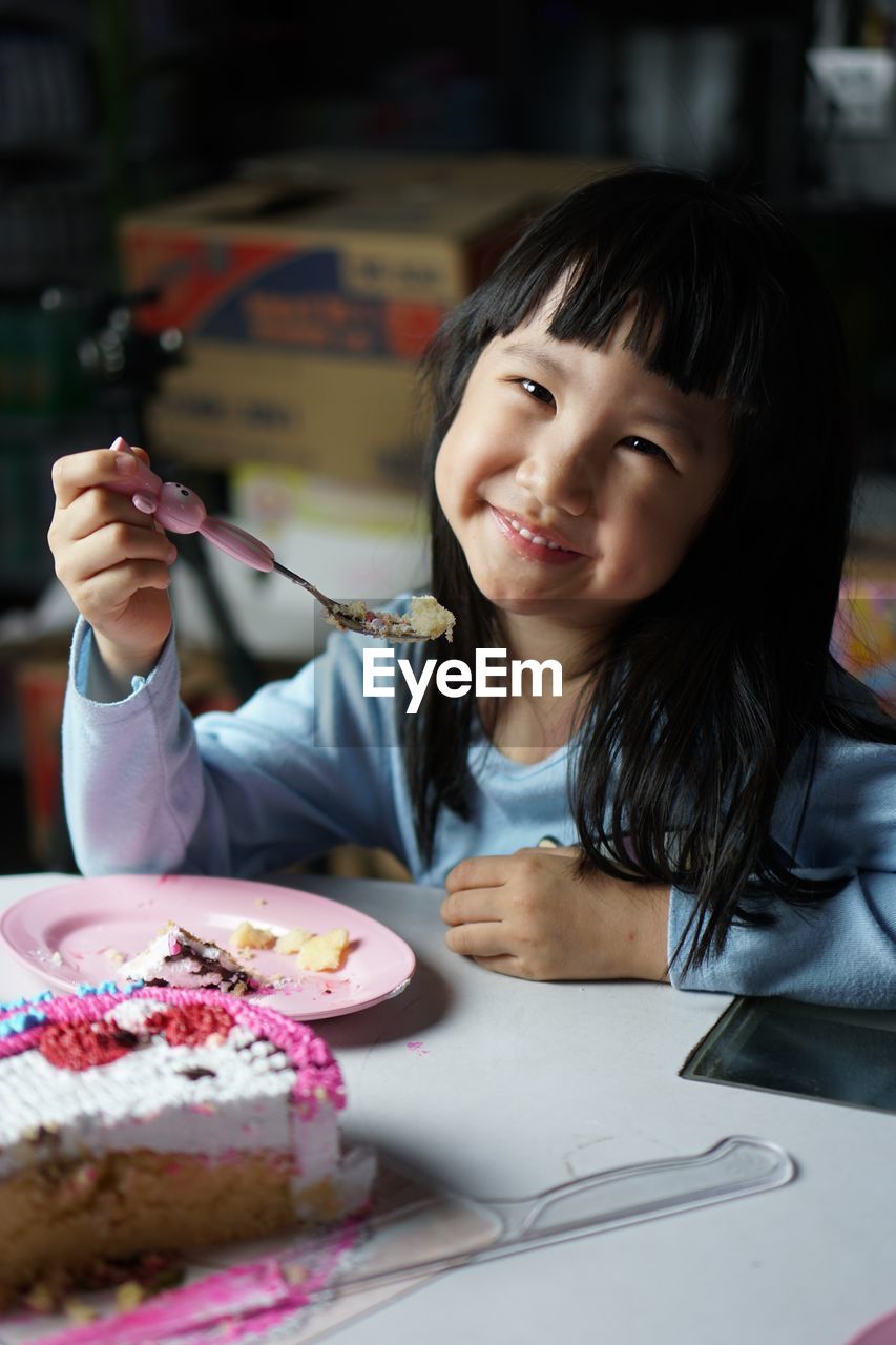 Portrait of smiling girl eating food in plate