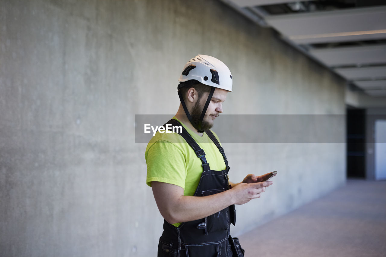 Worker using cell phone at building site