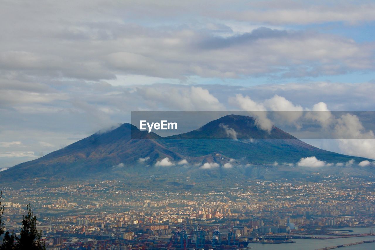 Aerial view of city and mountains against sky