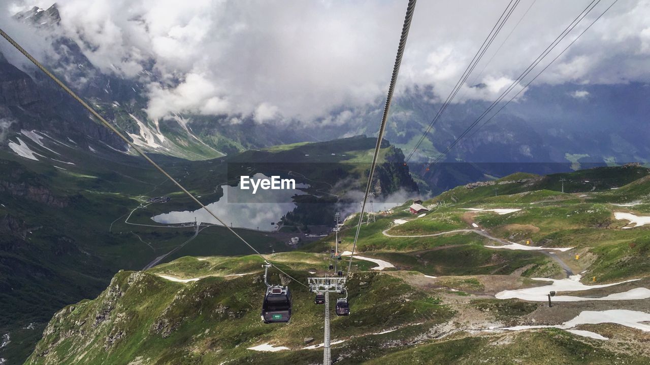Overhead cable car over mountain against sky
