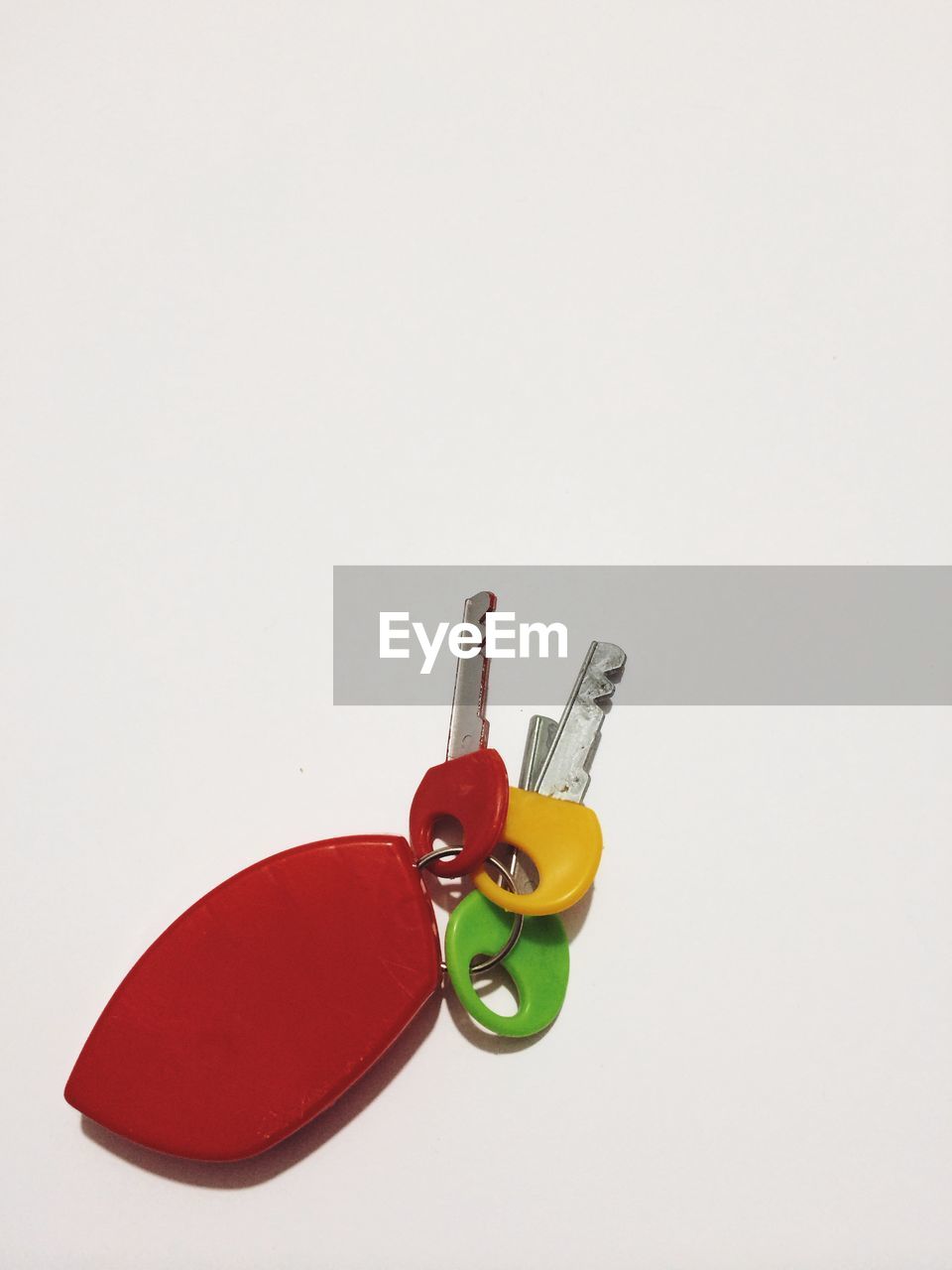 High angle view of colorful car keys against white background