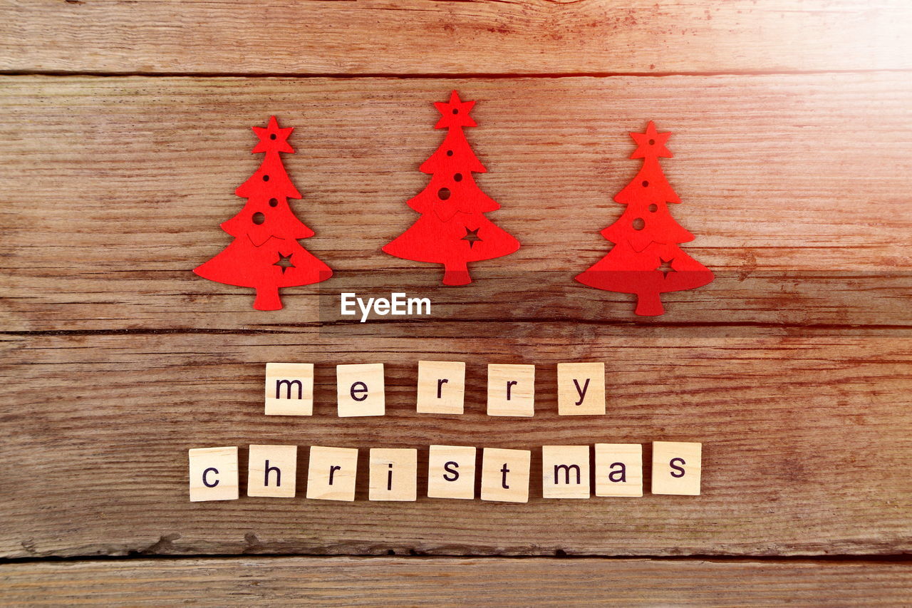 Close-up of text on wooden blocks with artificial christmas tree at table