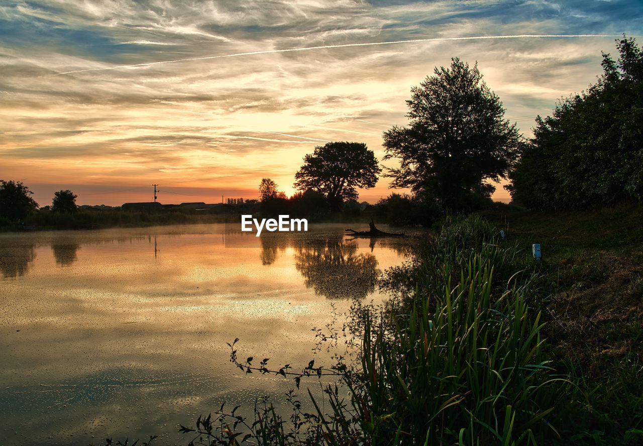 SCENIC VIEW OF LAKE AGAINST ORANGE SKY