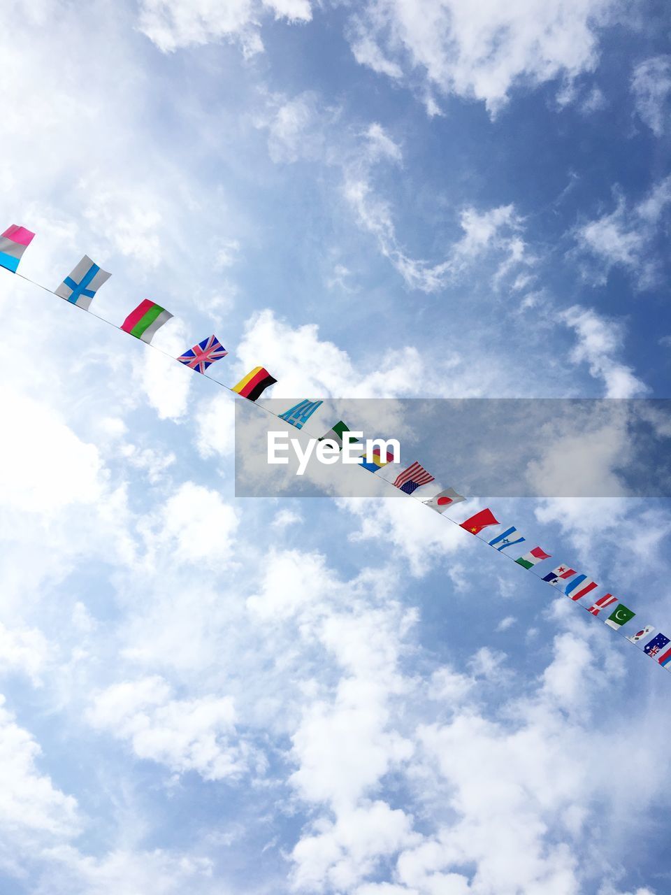 Low angle view of colorful flags against sky