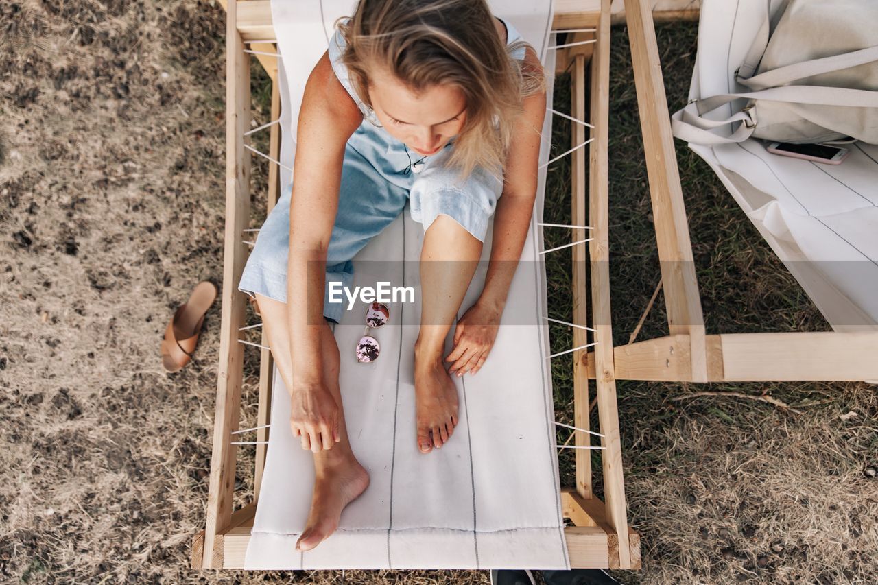 High angle view of thoughtful woman sitting on deck chair