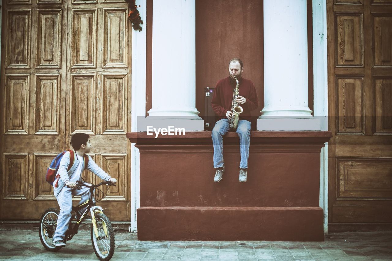 FULL LENGTH OF MAN SITTING ON WALL