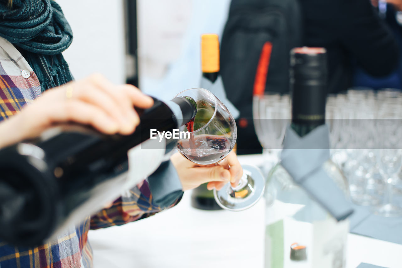 Midsection of woman holding wine glass