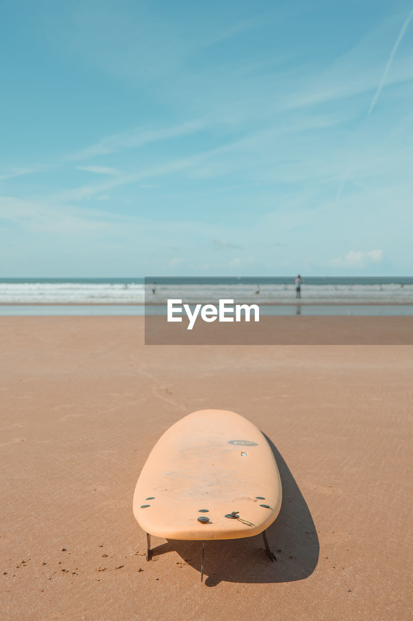 land, beach, sea, sky, water, sand, nature, horizon over water, ocean, scenics - nature, horizon, beauty in nature, tranquility, tranquil scene, natural environment, day, body of water, surfing equipment, no people, shore, outdoors, cloud, coast, blue, sunlight, surfboard, idyllic, wave, vacation, trip