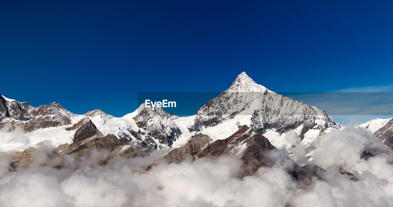 Scenic view of snow covered mountains against sky